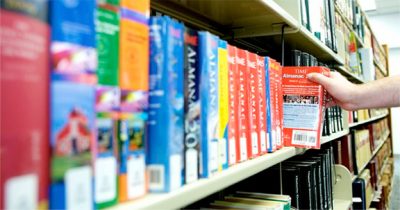 Hand reaching for a book in library