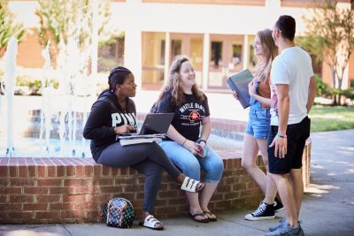 Four Students hanging out at the Davidson-Davie courtyard fountain