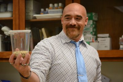Instructor Joe Felts holds a concealed cup of insects.
