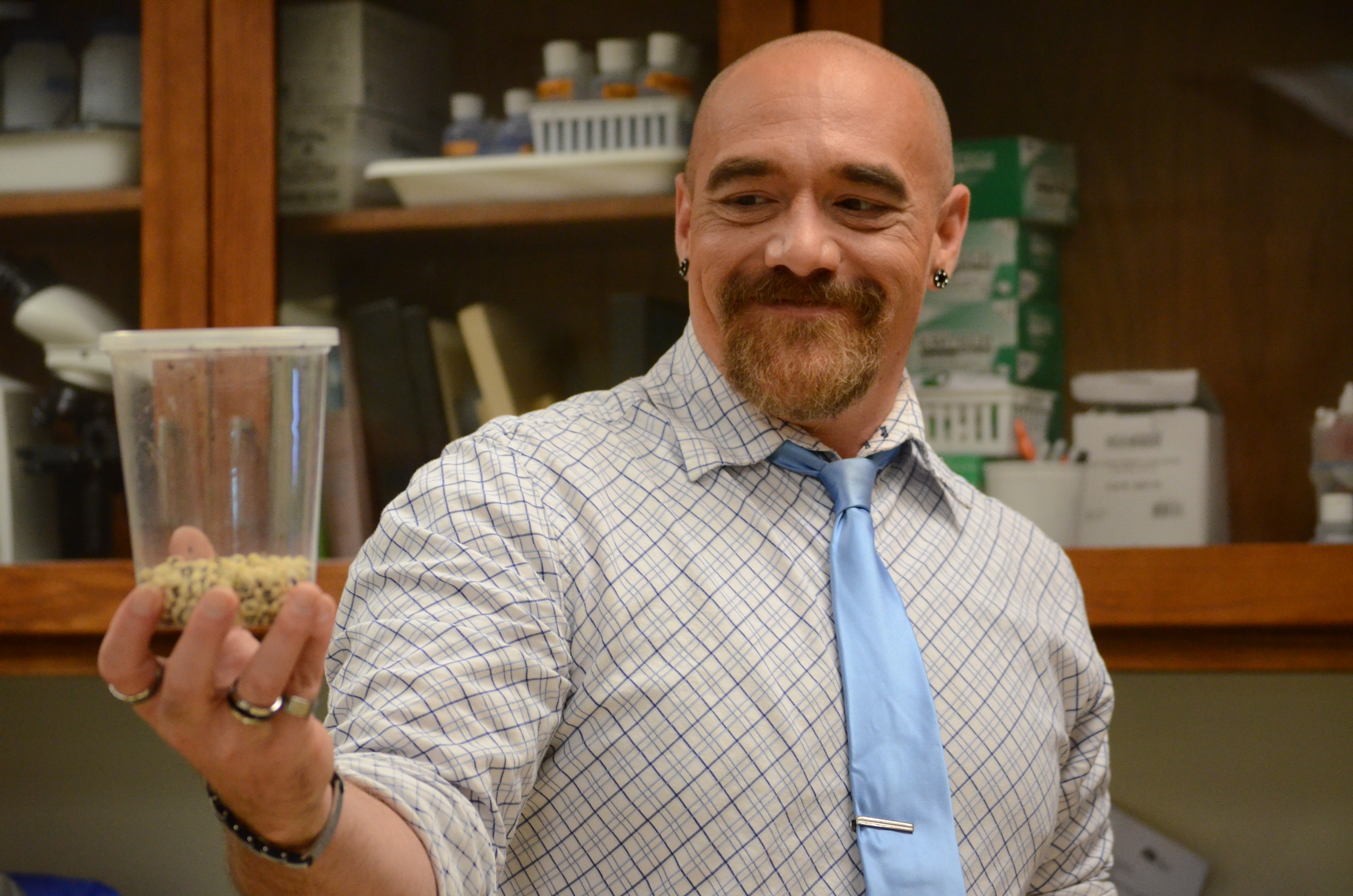 Instructor Joe Felts holds a concealed cup of insects.