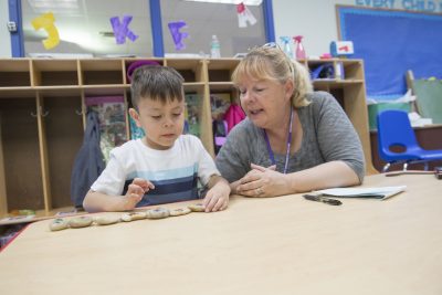 Teacher instructing young student.