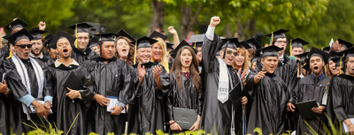 Large group of graduates cheering.