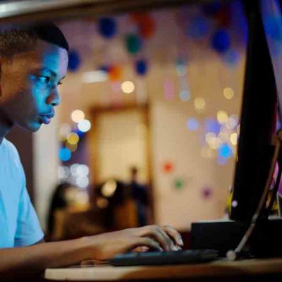 Student using computer in dark rom