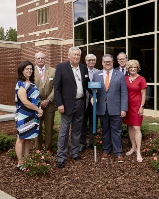 DCCC leadership stands beside plaque outside Davie campus.