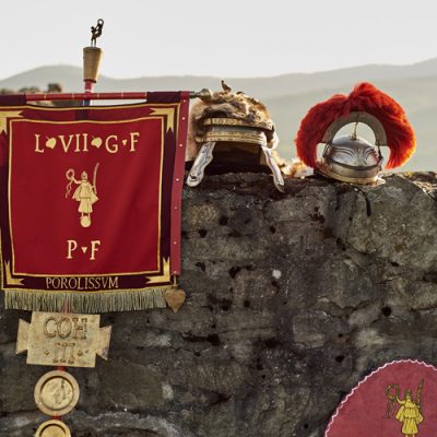 Roman Legion helmets and other items sitting on stone wall