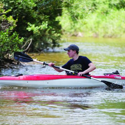 Individual in black T-shirt in red kayak