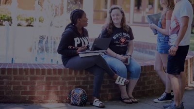 Four Students hanging out by the DCCC Fountain