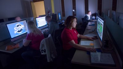 Students working in dim computer lab. Text reads: "Digital Media Production Program Info Session"