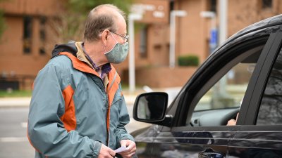 volunteer gathering information from driver of car