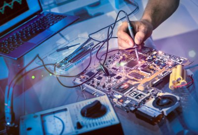 Tech fixes motherboard with soldering iron