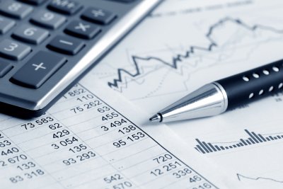 Calculator and pen laying on top of financial paperwork
