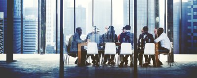 group of individuals gathered around table in large office conference room