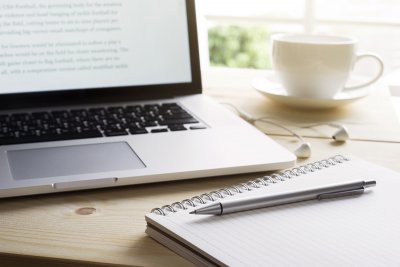 laptop and notepad sitting on top of desk