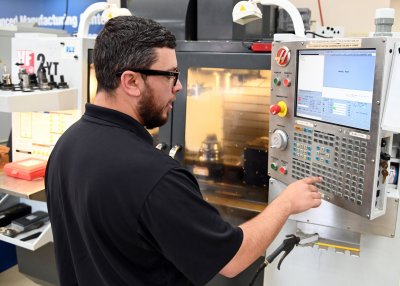 Student Operates Computer Integrated Machining Equipment keypad
