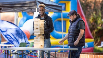 Two college students playing with oversized Jenga blocks