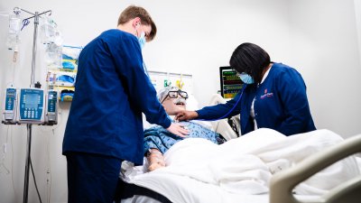 Two nursing students check vitals