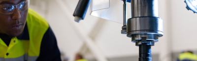 Manufacturing Apprentice looks closely at drill press
