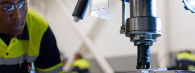 Manufacturing Apprentice looks closely at drill press