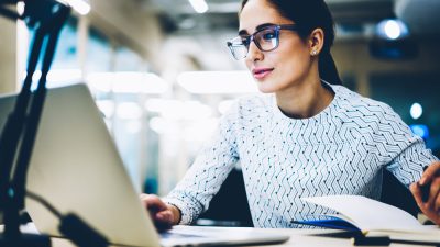 Professional Woman with glasses in front of laptop