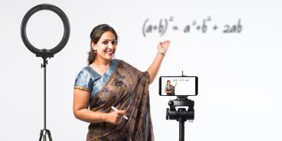 Teacher recording herself teaching math on white board