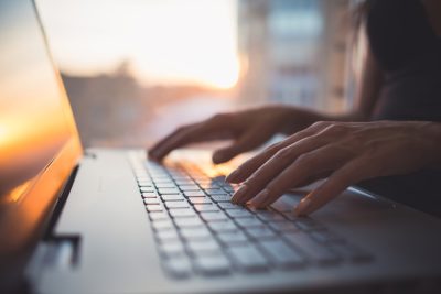 Closeup photo of hands typing on keyboard