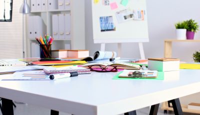 Art supplies scattered on white desk