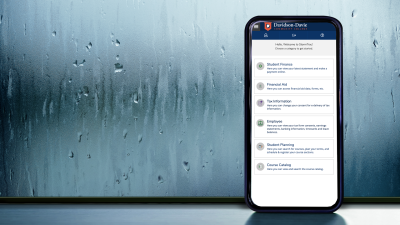 Phone with StormTrac dashboard on screen in front of window pane with rain on it