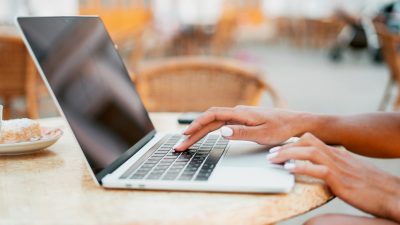close up photo of hands typing on a laptop computer