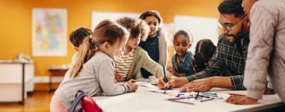Elementary teacher works with students at table