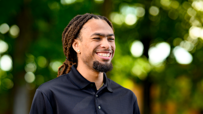Student in black polo smiles in the Davidson-Davie Community College courtyard