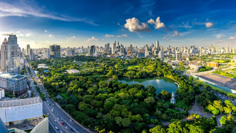 Sunset scence of modern office buildings and condominium in Bangkok city downtown with sunset sky and clouds at Bangkok , Thailand. Lumpini park