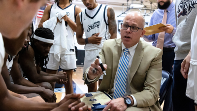 Matt Ridge coaching basketball players in a huddle