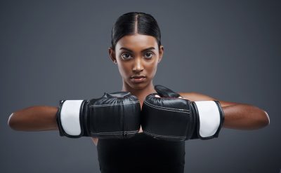 Girl wearing black boxing glves