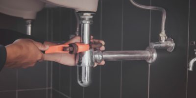 plumber at work in a bathroom, plumbing repair service , fix water plumbing leaks, replace the kitchen sink drain