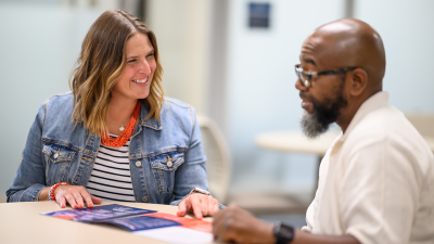 Two people sitting at a table, engaging in conversation.