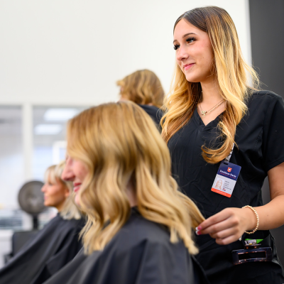 A hair stylist in a salon working on a client's hair.