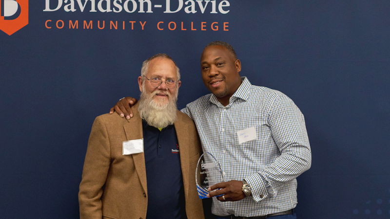 Agape Homes, LLC owner, Travis Bobo, holds award.