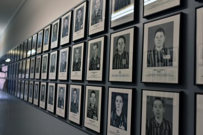 A hallway lined with framed black and white portraits of individuals in striped uniforms.
